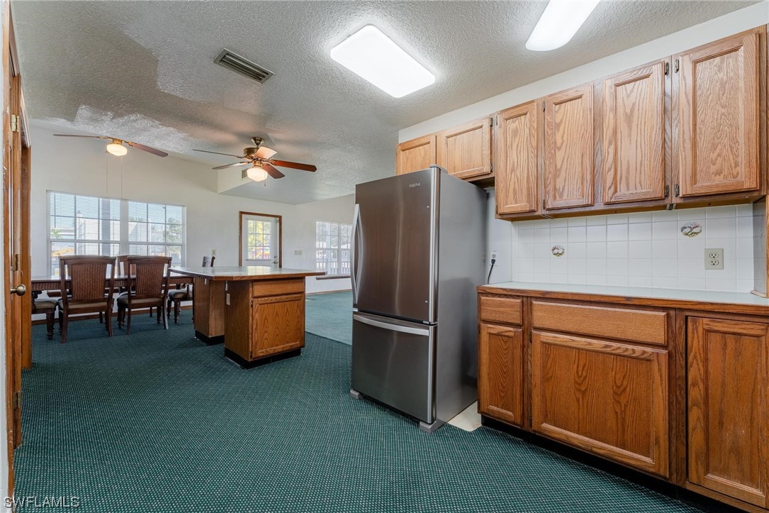 300 1st Street Moore Haven, FL 33471 - Photo 25 of 45 a kitchen with stainless steel appliances granite countertop a refrigerator a sink dishwasher a stove and a refrigerator with wooden floor