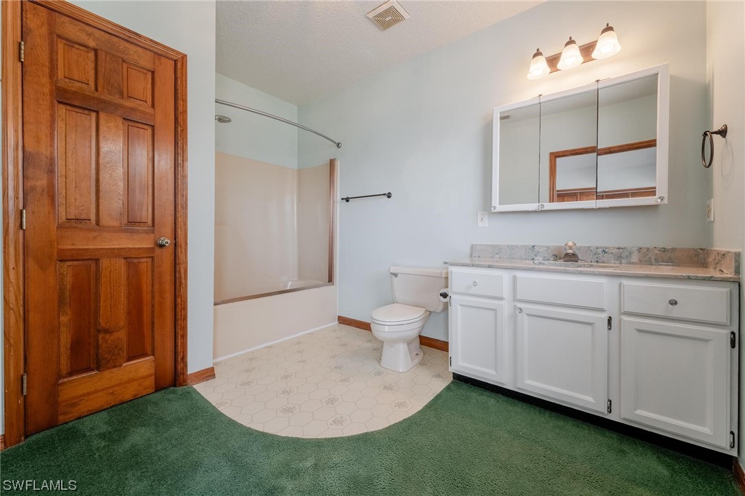 300 1st Street Moore Haven, FL 33471 - Photo 32 of 45 a spacious bathroom with a granite countertop sink and a mirror