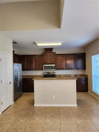 a kitchen with stainless steel appliances granite countertop a refrigerator and a stove top oven