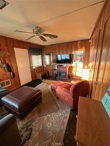 a living room with furniture a flat screen tv and a window