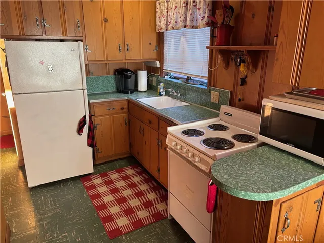 a kitchen with stainless steel appliances granite countertop a refrigerator a stove a sink and a refrigerator