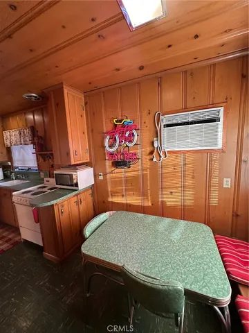 a kitchen with stainless steel appliances kitchen island granite countertop a table chairs in it and wooden floors