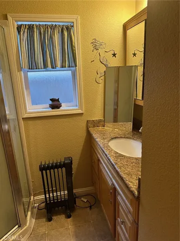 a bathroom with a granite countertop sink and a mirror