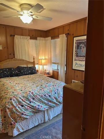 a bedroom with a bed and a dresser with rug