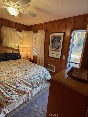 a bedroom with a bed and dresser with mirror