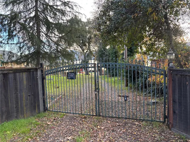 a view of backyard with wooden fence and trees