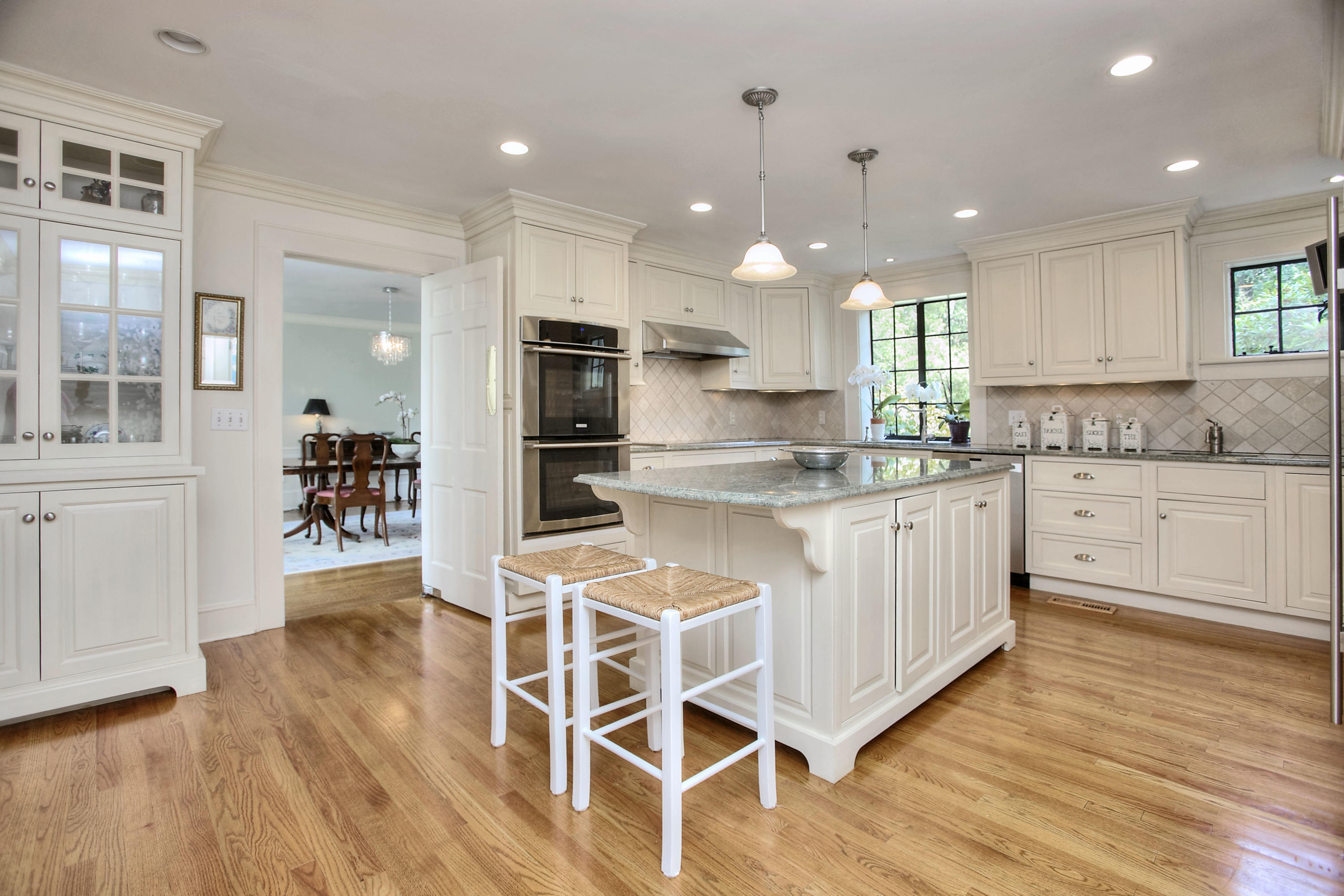9 Sunswyck Road Darien, CT 06820 - Photo 16 of 43 a kitchen with stainless steel appliances kitchen island granite countertop a wooden floor and white cabinets