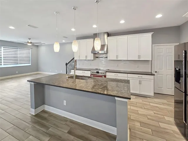 a kitchen with stainless steel appliances granite countertop a sink stove and refrigerator