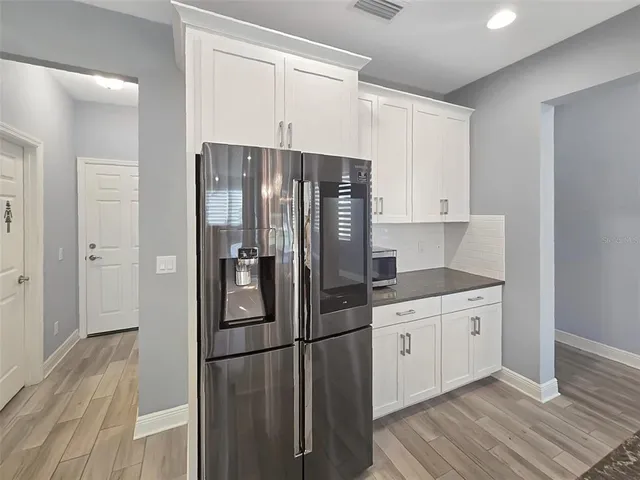 a kitchen with a refrigerator sink and cabinets