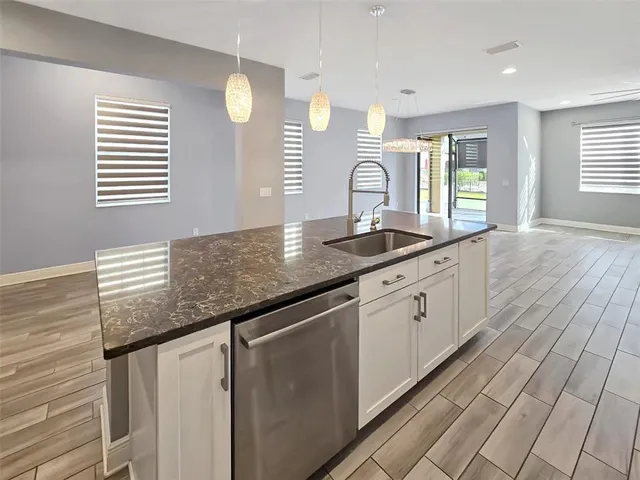 a kitchen with granite countertop white cabinets and window