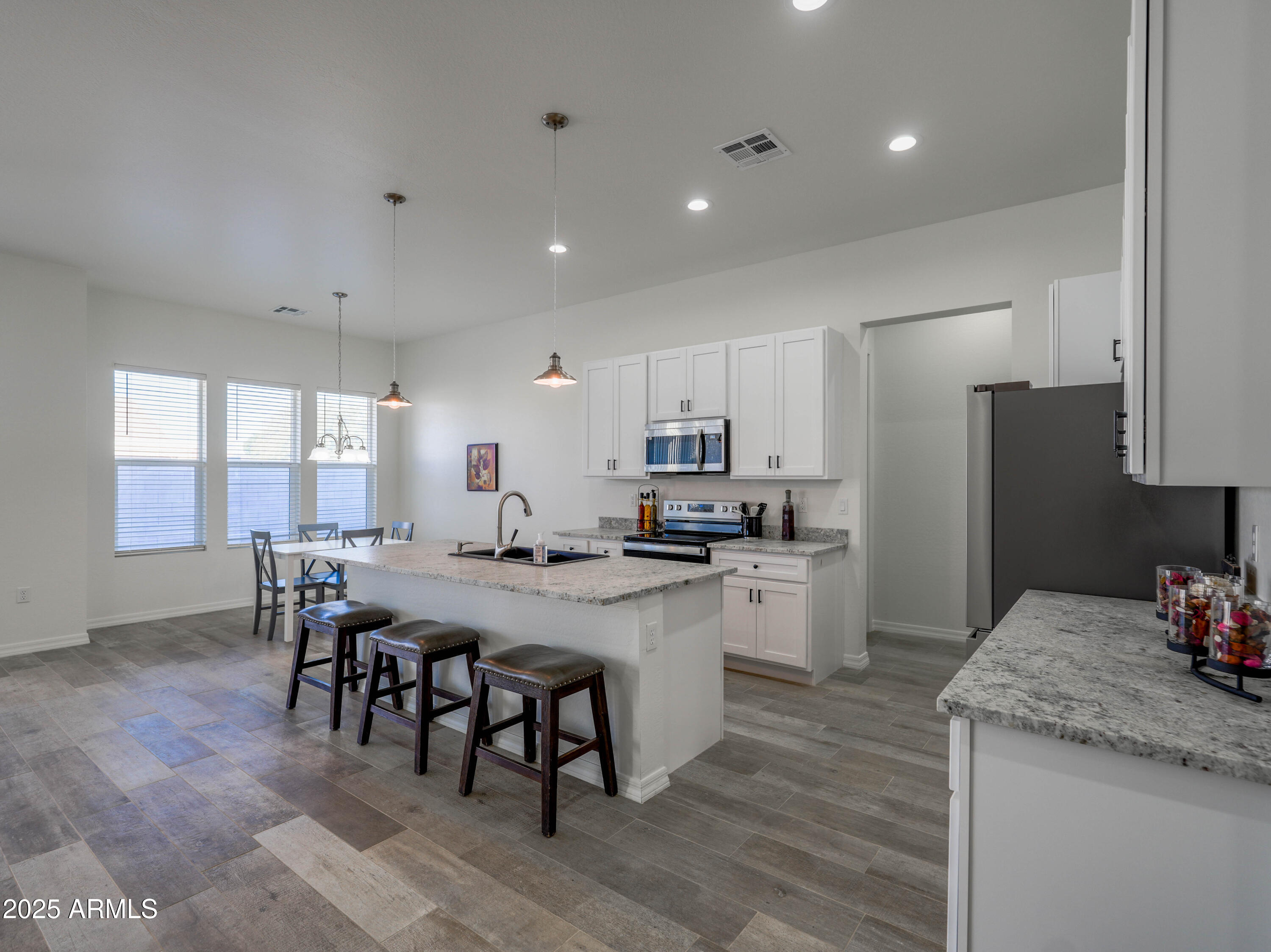 14554 South Diablo Road Arizona City, AZ 85123 - Photo 3 of 33 a kitchen with a dining table chairs refrigerator and microwave