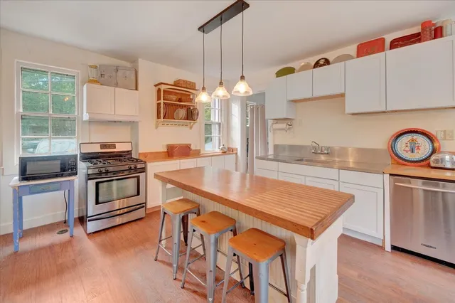 a large kitchen with kitchen island a large counter top space a sink stainless steel appliances and cabinets