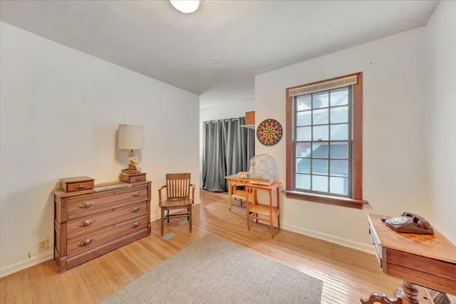 a living room with a couch piano table and wooden floor