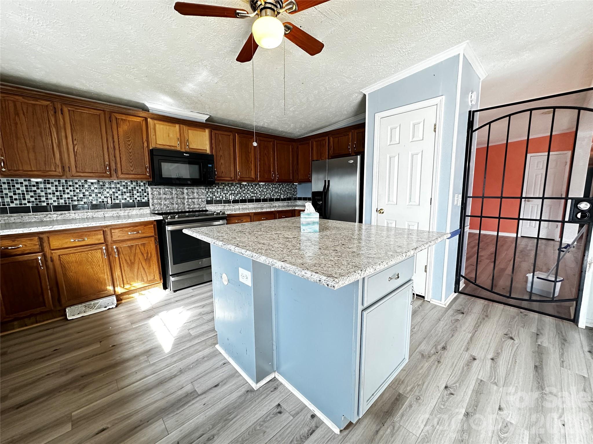 7447 Highway 64, Unit 2 Morganton, NC 28655 - Photo 13 of 27 a kitchen with stainless steel appliances granite countertop wooden floors and white cabinets