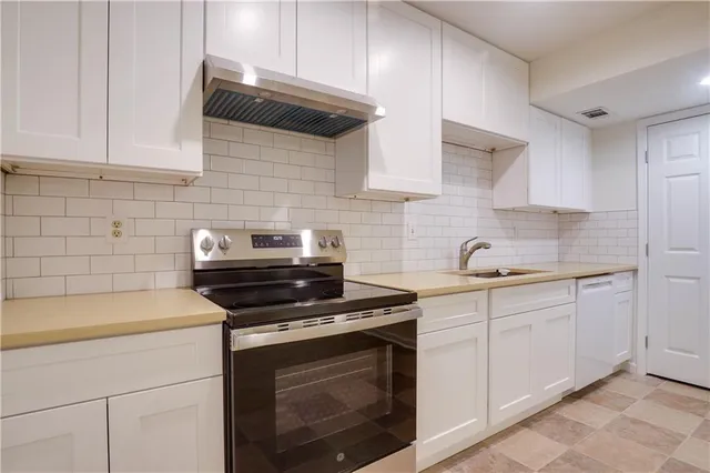 a kitchen with cabinets stainless steel appliances and wooden floor