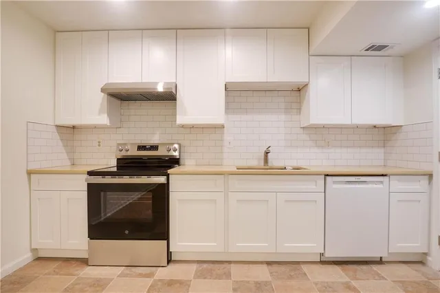 a kitchen with white cabinets stainless steel appliances and sink