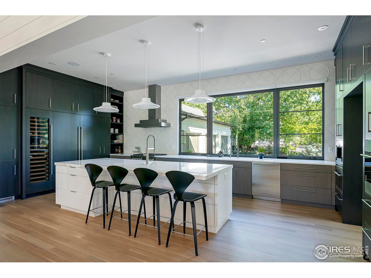 3621 21st Street Boulder, CO 80304 - Photo 12 of 50 The centerpiece of the home, the gourmet kitchen, boasts an impressive center island with seating for four, marble and quartz countertops, artisanal tile, custom contrasting white and dark cabinetry, top-tier chef's appliances, and a walk-in pantry