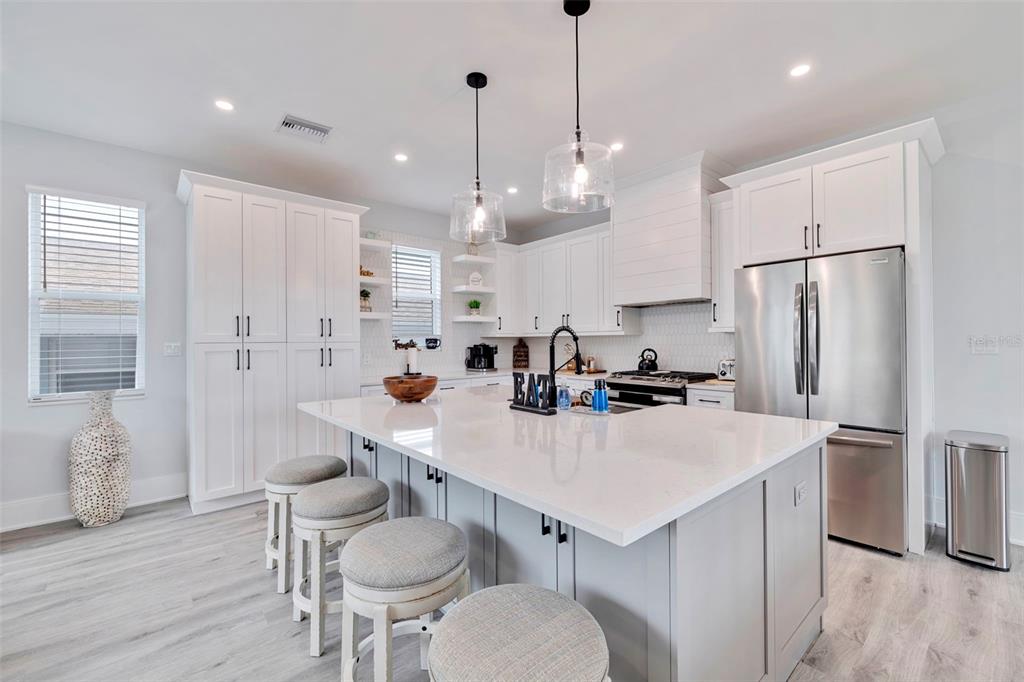 1800 Gulf Boulevard, Unit 1 Indian Rocks Beach, FL 33785 - Photo 18 of 97 a kitchen with sink a refrigerator and chairs