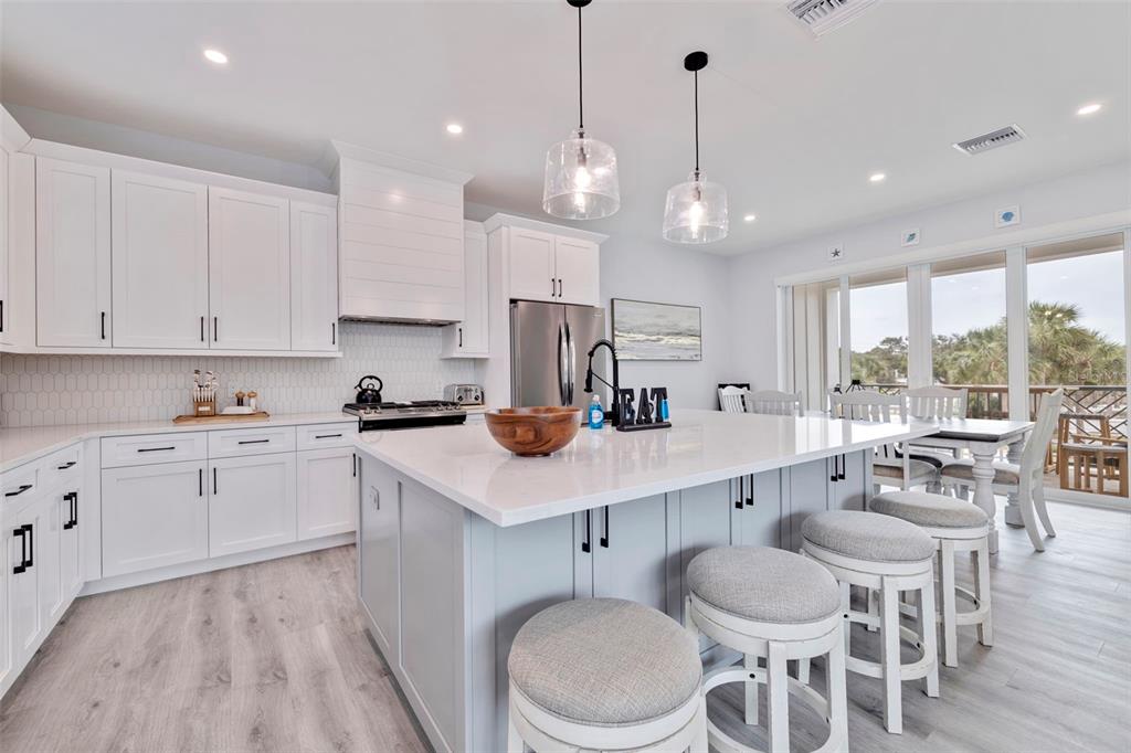 1800 Gulf Boulevard, Unit 1 Indian Rocks Beach, FL 33785 - Photo 20 of 97 a kitchen with a dining table chairs sink and cabinets