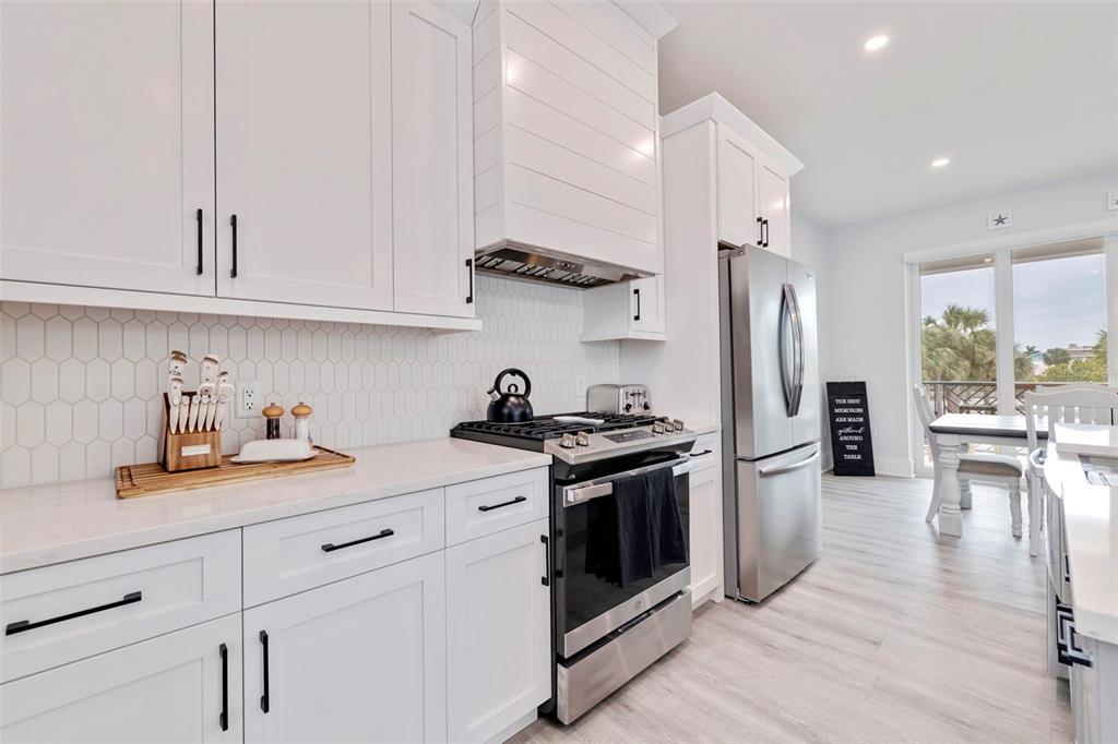 1800 Gulf Boulevard, Unit 1 Indian Rocks Beach, FL 33785 - Photo 24 of 97 a kitchen with stainless steel appliances granite countertop a refrigerator stove and sink