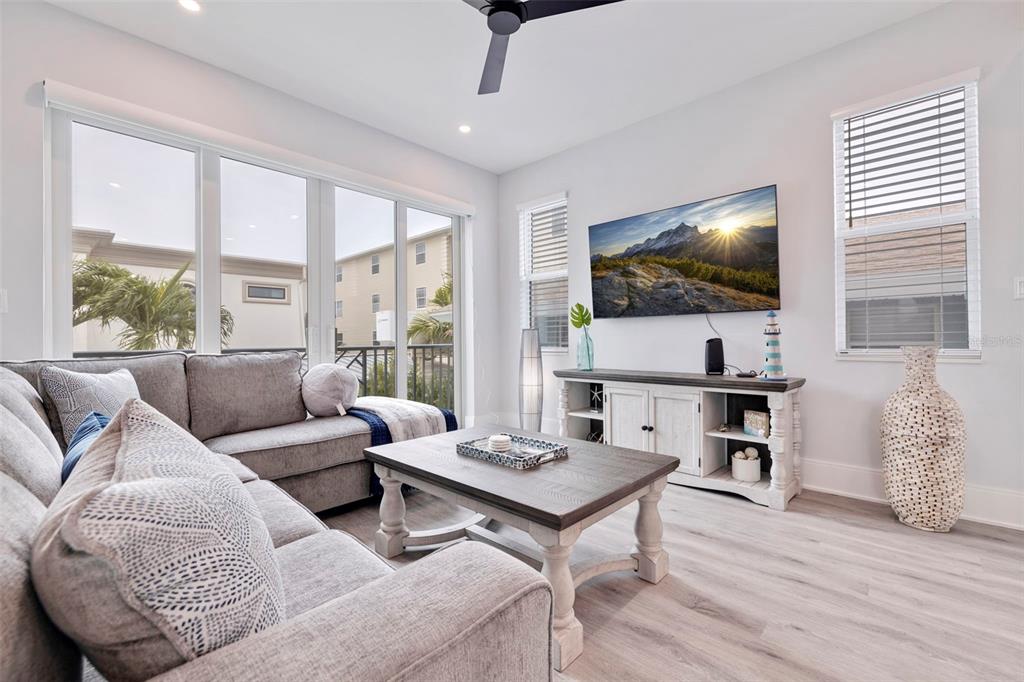 1800 Gulf Boulevard, Unit 1 Indian Rocks Beach, FL 33785 - Photo 34 of 97 a living room with furniture a large window and a flat screen tv