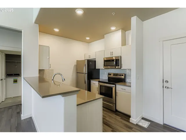 a kitchen with stainless steel appliances granite countertop a sink refrigerator and microwave