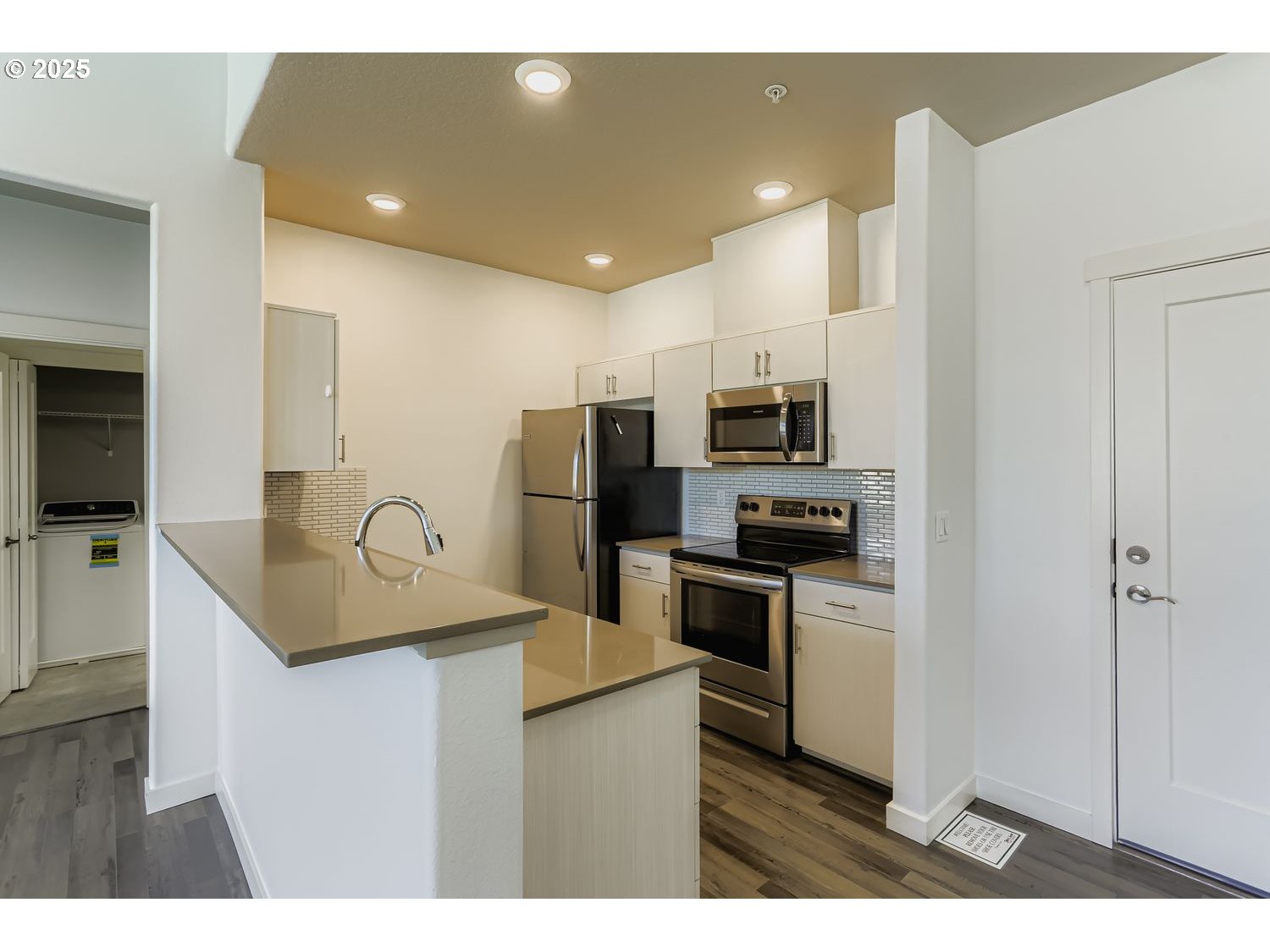 16449 Northwest Chadwick Way, Unit 305 Portland, OR 97229 - Photo 3 of 11 a kitchen with stainless steel appliances granite countertop a sink refrigerator and microwave