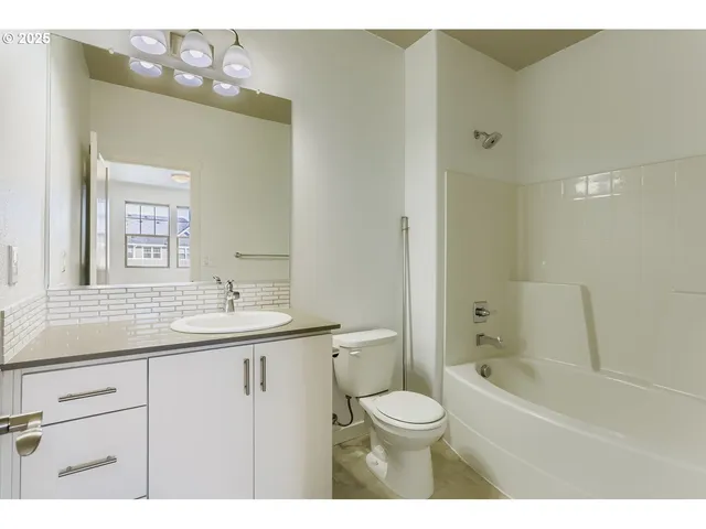 a bathroom with a granite countertop sink a toilet and shower