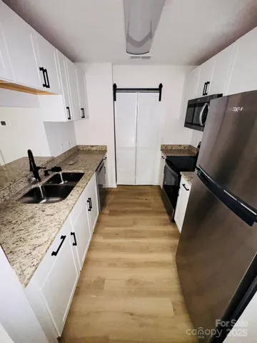 a kitchen with kitchen island sink stove and refrigerator