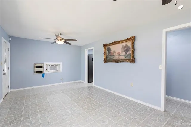 a view of an empty room with a chandelier fan