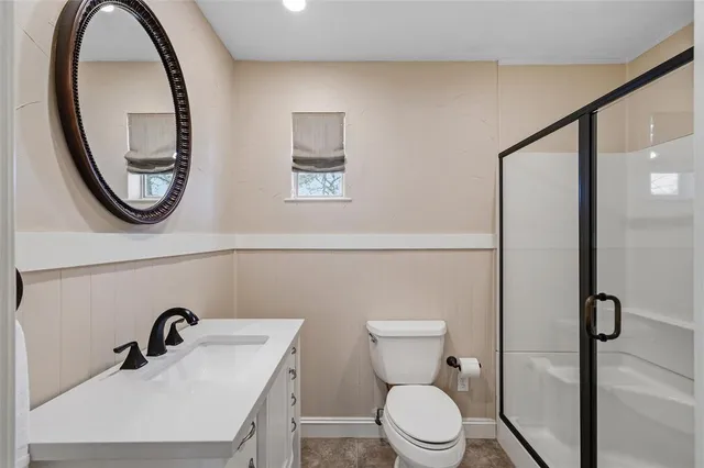 a bathroom with a toilet a sink and a mirror