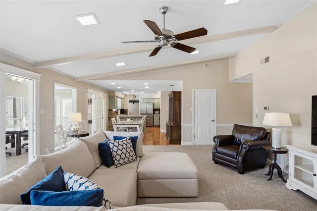 a living room with furniture and a view of kitchen
