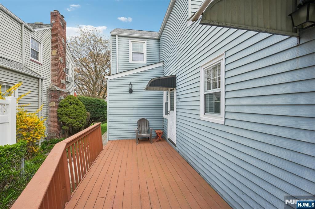 401 Walnut Street Nutley, NJ 07110 - Photo 22 of 25 a view of a balcony with wooden floor and fence and a floor to ceiling window
