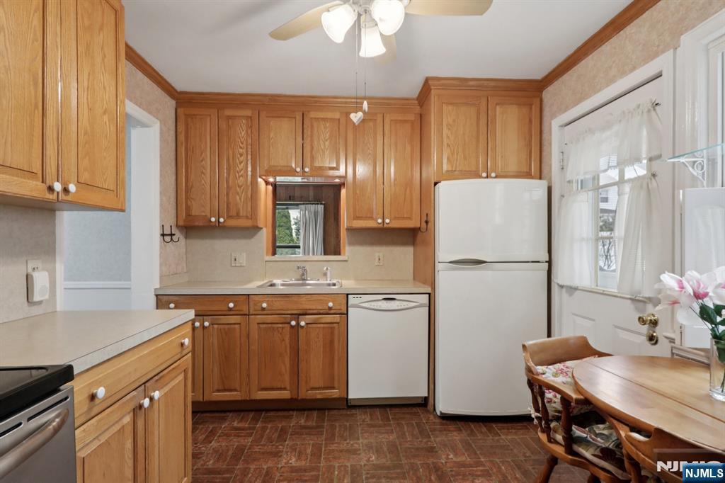 401 Walnut Street Nutley, NJ 07110 - Photo 8 of 25 a kitchen with stainless steel appliances granite countertop a refrigerator a sink dishwasher a stove with white cabinets and wooden floor