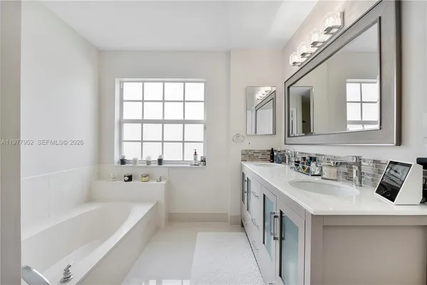 a bathroom with a tub sink and mirror