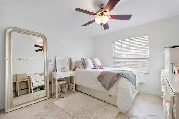 a bedroom with a bed and a ceiling fan