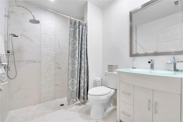 a bathroom with a sink toilet and shower