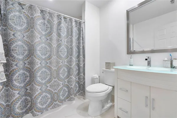 a bathroom with a sink toilet and shower