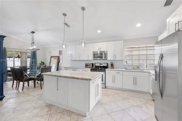 a kitchen with white cabinets and white appliances