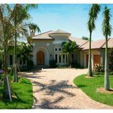 a front view of a house with a yard and potted plants