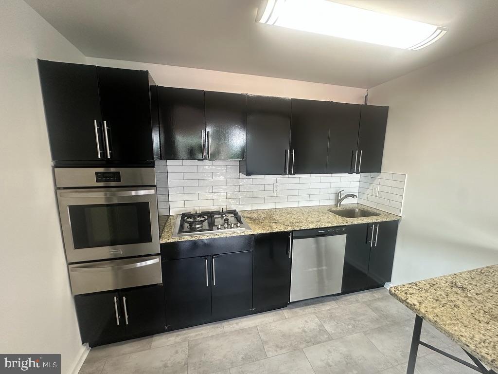1401 Pennsylvania Avenue, Unit 612 Wilmington, DE 19806 - Photo 14 of 37 a kitchen with stainless steel appliances kitchen island granite countertop a stove a sink and a refrigerator