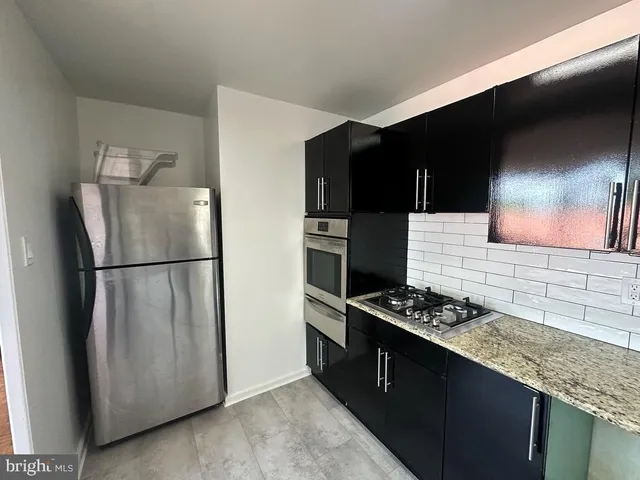 a kitchen with stainless steel appliances granite countertop a refrigerator and a stove top oven