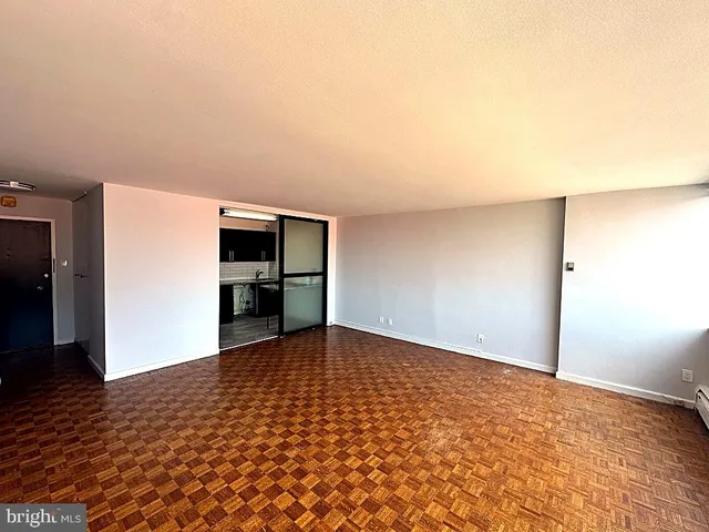 a view of empty room with wooden floor