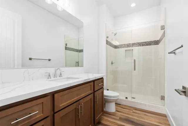 a bathroom with a sink a toilet and shower