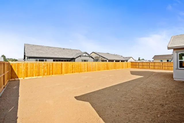 a view of an house with backyard and road