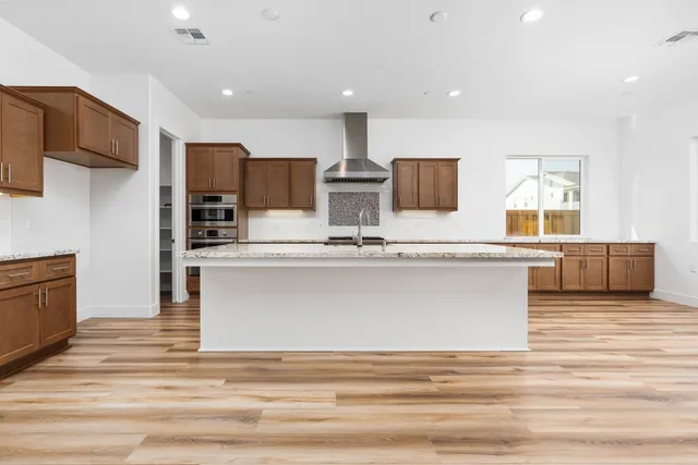 a kitchen with stainless steel appliances granite countertop sink stove and refrigerator