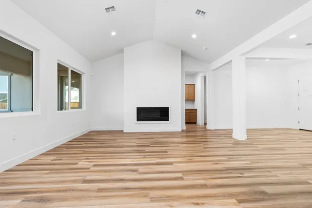 a big room with wooden floor and windows