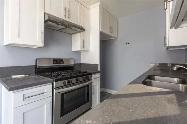 a kitchen with stainless steel appliances granite countertop white cabinets and stove