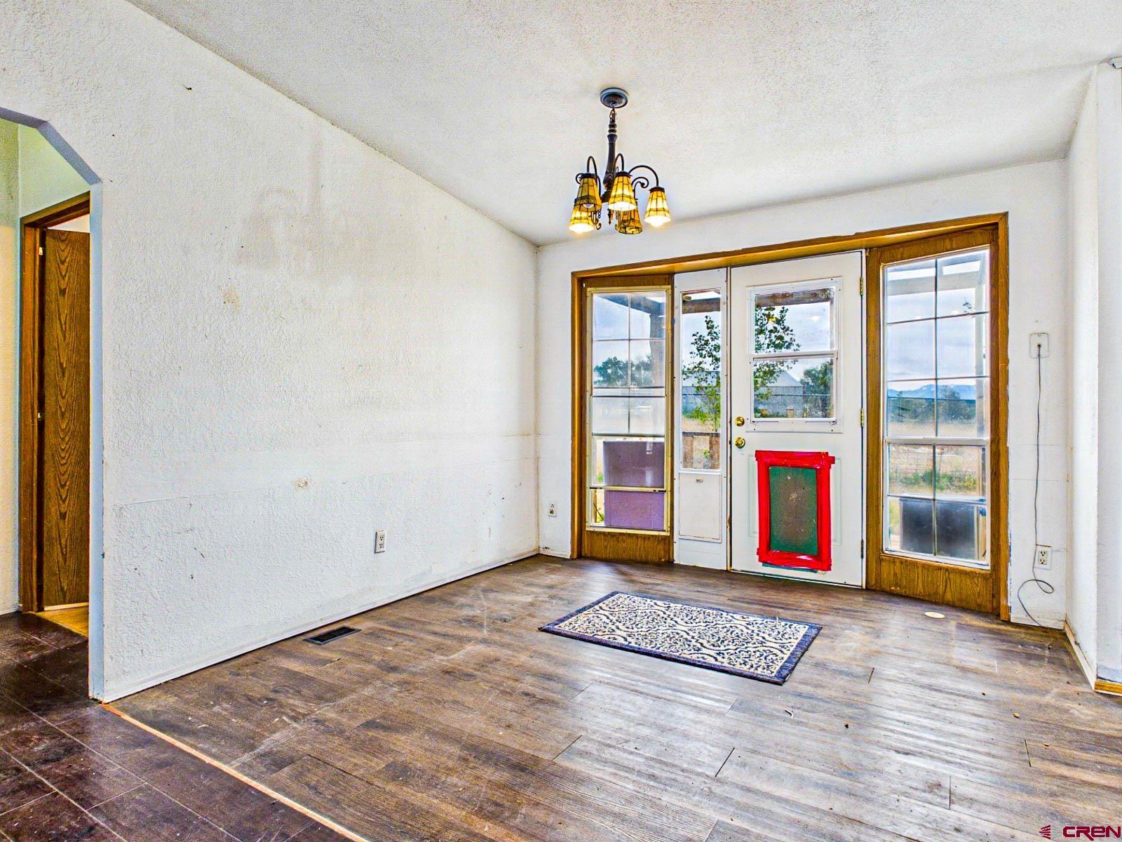 15484 Peach Road Cedaredge, CO 81413 - Photo 10 of 35 a view of an empty room with a window and wooden floor