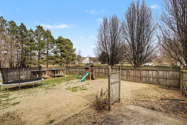 a view of a yard with wooden fence